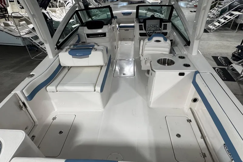 Slide: The Image of 2026 Robalo R257 Dual Console boat interior with seating and helm, showcased in a showroom. - 17