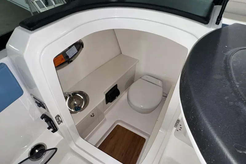 Slide: The Image of 2026 Robalo R257 Dual Console boat interior with compact bathroom and sink. - 23