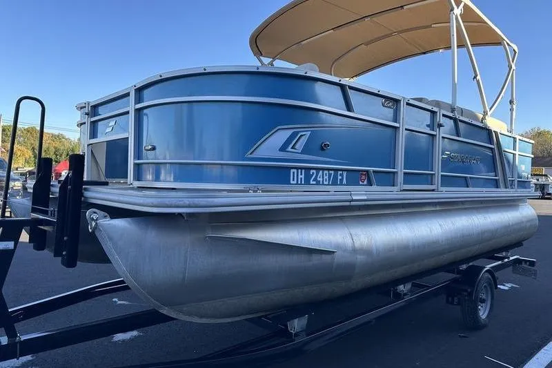 The Image of 2019 Starcraft EX 20 F4 pontoon boat with blue exterior and canopy on trailer. - 0