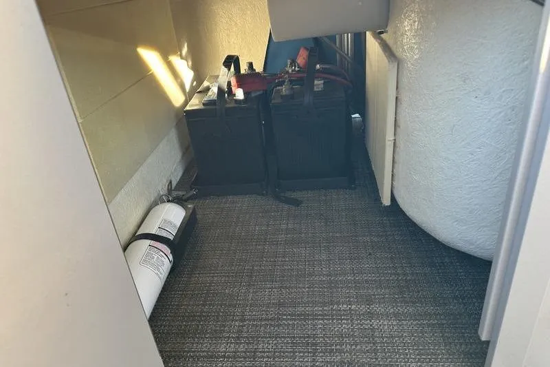 Slide: The Image of 2019 Starcraft EX 20 F4 storage area with batteries and fire extinguisher. - 22