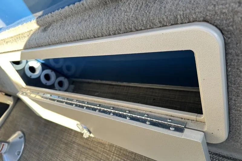 Slide: The Image of 2019 Starcraft EX 20 F4 boat storage compartment with visible cup holders. - 24