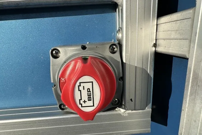 Slide: The Image of Red battery switch on 2019 Starcraft EX 20 F4 boat, mounted on blue panel. - 25