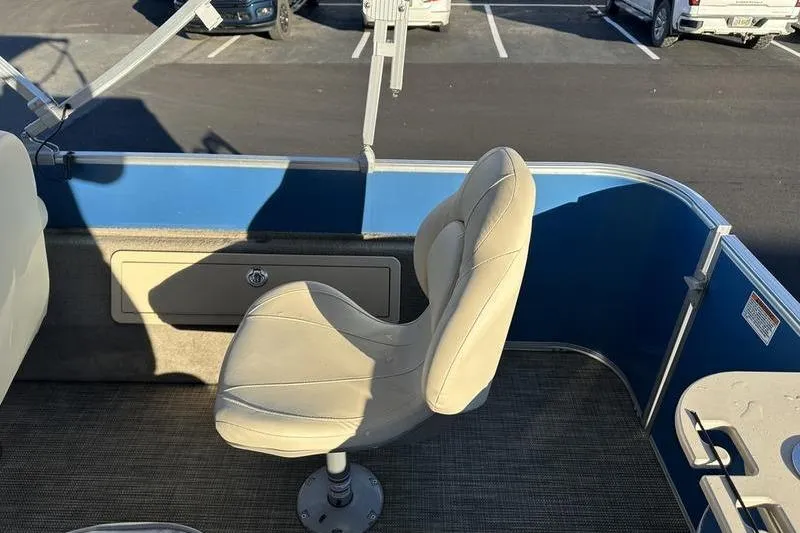 Slide: The Image of 2019 Starcraft EX 20 F4 boat interior with beige swivel seat and blue paneling. - 29