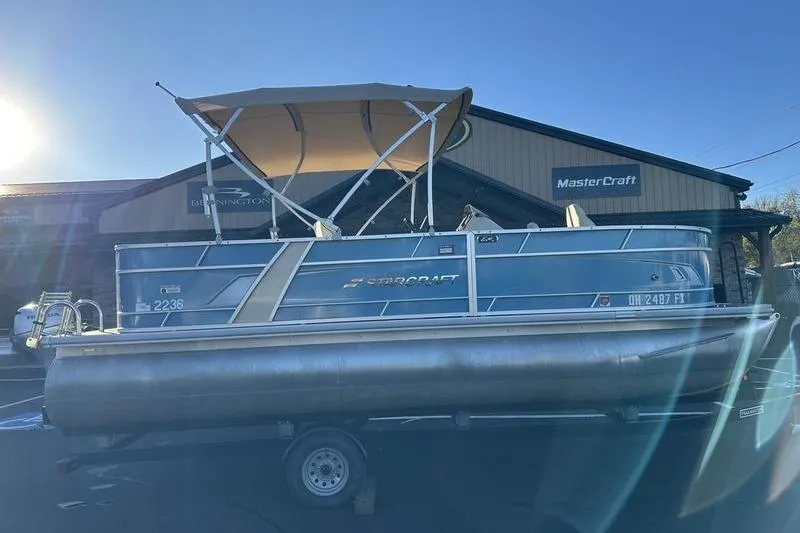 Slide: The Image of 2019 Starcraft EX 20 F4 pontoon boat with canopy on trailer, parked outside. - 3