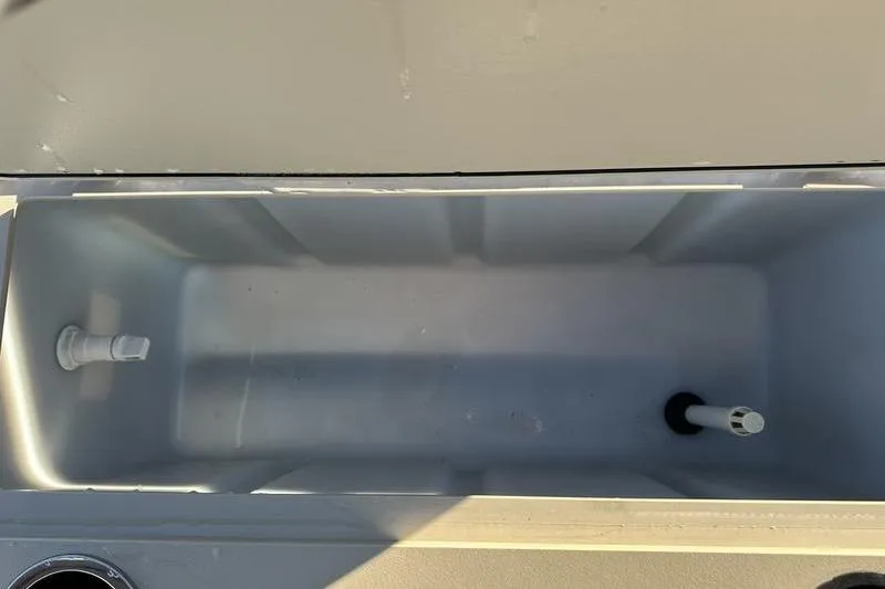 Slide: The Image of 2019 Starcraft EX 20 F4 boat storage compartment, open and empty, with visible fittings. - 30