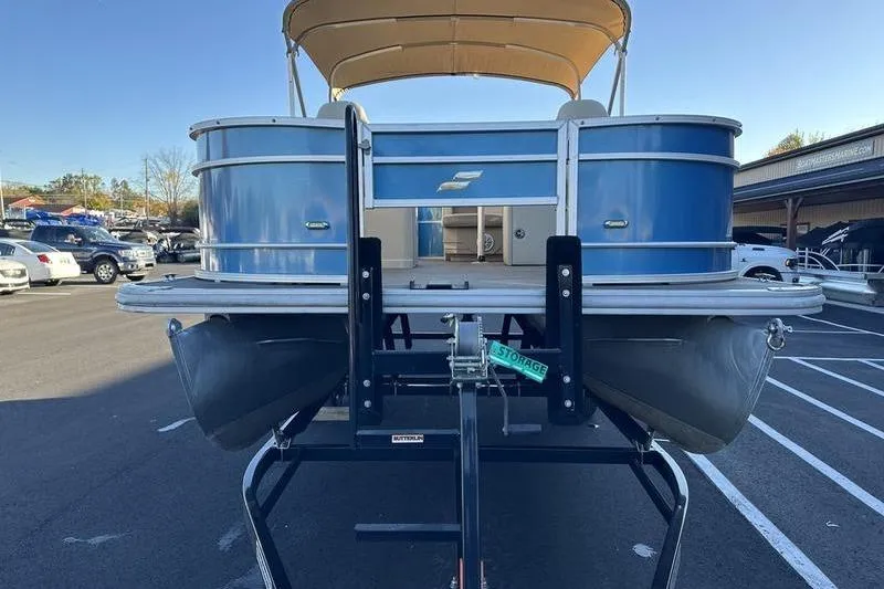 Slide: The Image of 2019 Starcraft EX 20 F4 pontoon boat on trailer, parked in a lot. - 4