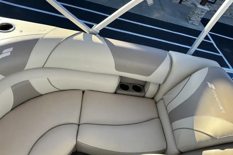 Slide: The Image of 2019 Starcraft EX 20 F4 boat interior with beige seating and cup holders. - 9