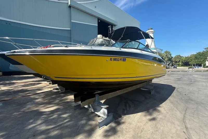 The Image of 2015 Monterey 264FS boat in vibrant yellow, docked outdoors under clear blue sky. - 0