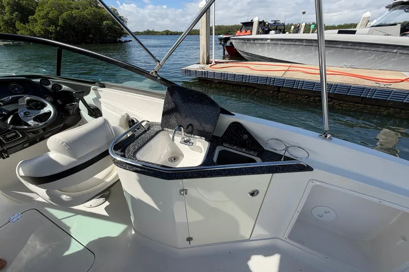 Slide: The Image of 2015 Monterey 264FS boat interior with steering wheel and sink, docked by the water. - 12
