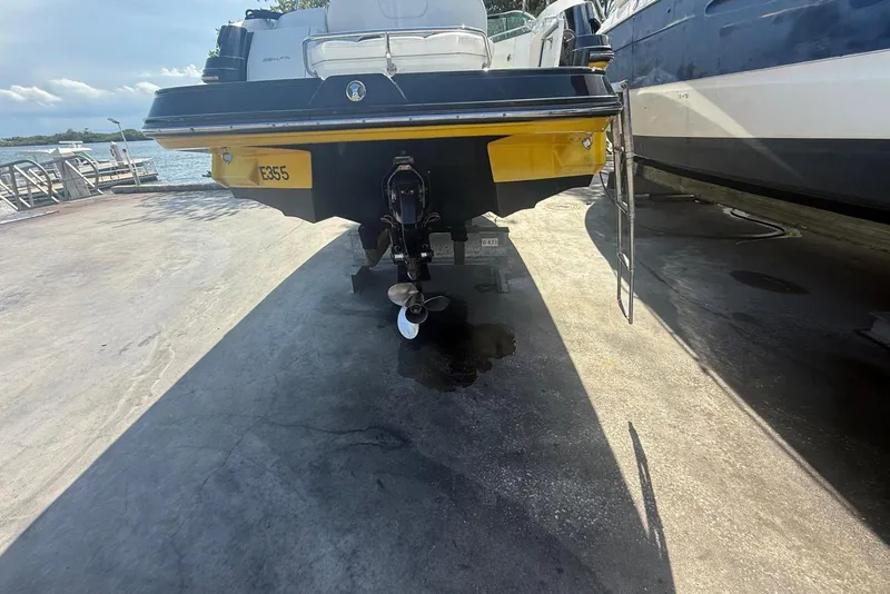 Slide: The Image of Rear view of a 2015 Monterey 264FS boat on a dock, showing the propeller and ladder. - 4