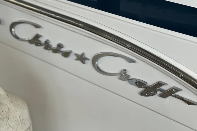 Slide: The Image of Close-up of 2000 Chris-Craft 308 Express Cruiser logo on white surface. - 17