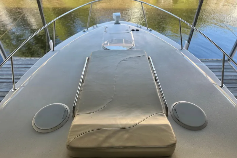 Slide: The Image of 2000 Chris-Craft 308 Express Cruiser deck with cushioned seating, docked by calm water. - 39