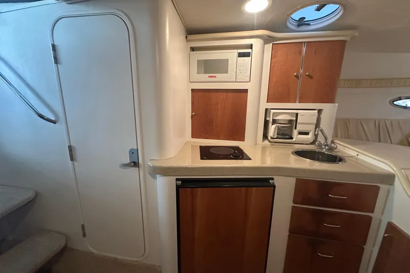 Slide: The Image of 2000 Chris-Craft 308 Express Cruiser interior kitchen with microwave, sink, and cabinets. - 44