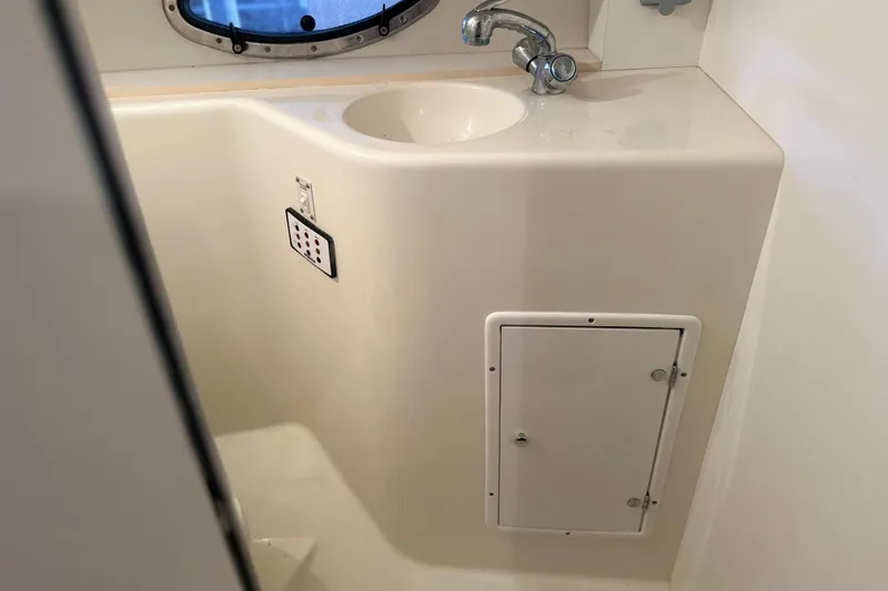 Slide: The Image of Bathroom sink area in a 2000 Chris-Craft 308 Express Cruiser boat. - 48