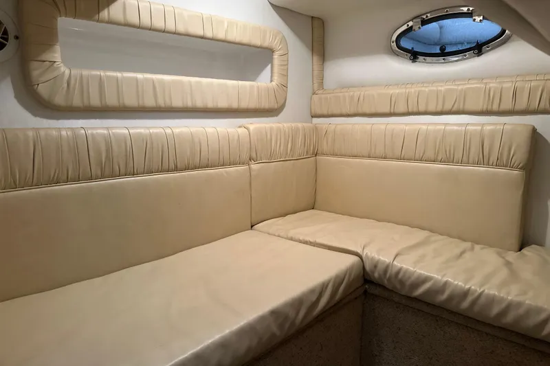 Slide: The Image of Interior of 2000 Chris-Craft 308 Express Cruiser with beige leather seating and porthole window. - 52