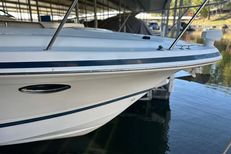 Slide: The Image of 2000 Chris-Craft 308 Express Cruiser docked, showcasing sleek white hull and blue accents. - 58