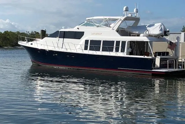 The Image of 2000 Pacific Mariner 65 Motoryacht docked on calm water, side view. - 0