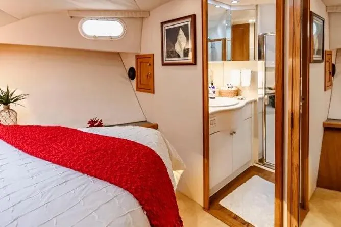 Slide: The Image of Luxurious cabin interior of 2000 Pacific Mariner 65 Motoryacht with red accents and ensuite bathroom. - 18