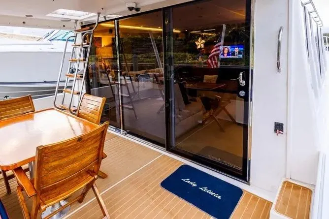 Slide: The Image of Outdoor deck of 2000 Pacific Mariner 65 Motoryacht with wooden dining set and glass doors. - 4