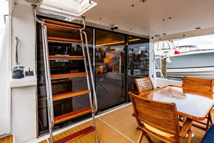 Slide: The Image of Outdoor deck of 2000 Pacific Mariner 65 Motoryacht with wooden table and ladder. - 46