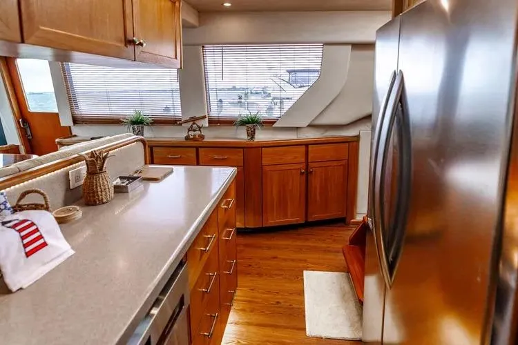 Slide: The Image of Luxurious kitchen interior of 2000 Pacific Mariner 65 Motoryacht with wooden cabinetry and stainless appliances. - 51
