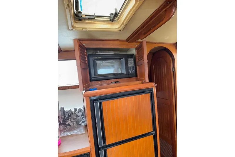 Slide: The Image of 1987 Monk 36 Trawler interior with microwave and wooden cabinetry. - 12