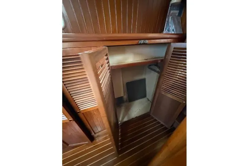 Slide: The Image of 1987 Monk 36 Trawler interior with wooden cabinetry and open closet space. - 13