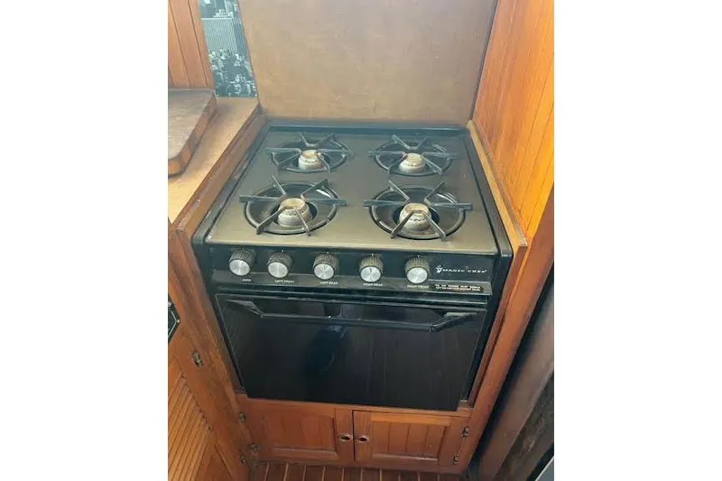 Slide: The Image of 1987 Monk 36 Trawler kitchen with a four-burner stove and oven. - 16