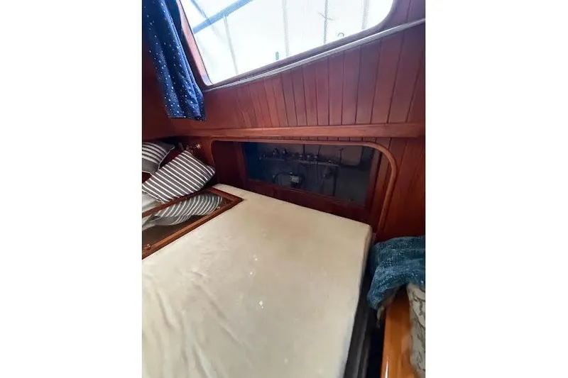 Slide: The Image of 1987 Monk 36 Trawler cabin interior with wooden paneling and bed. - 17