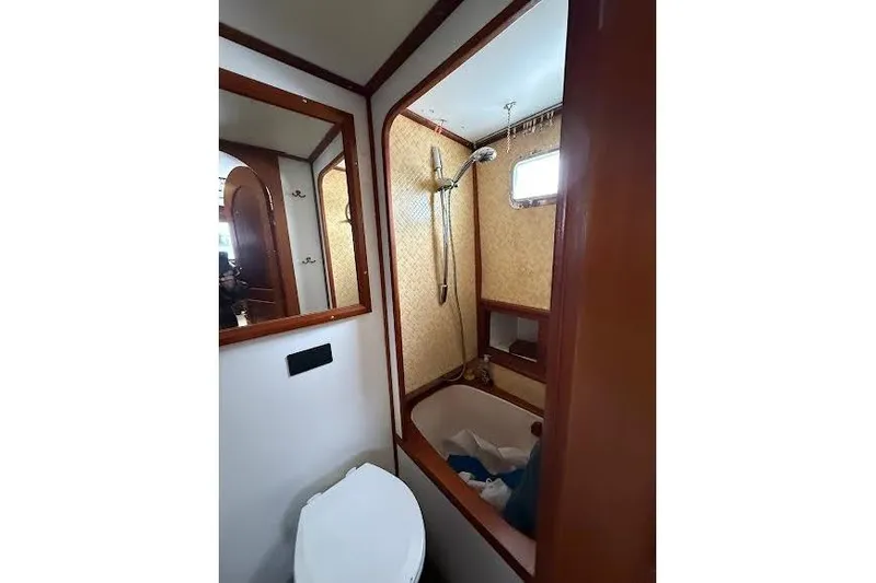 Slide: The Image of 1987 Monk 36 Trawler bathroom with shower, mirror, and wooden accents. - 18