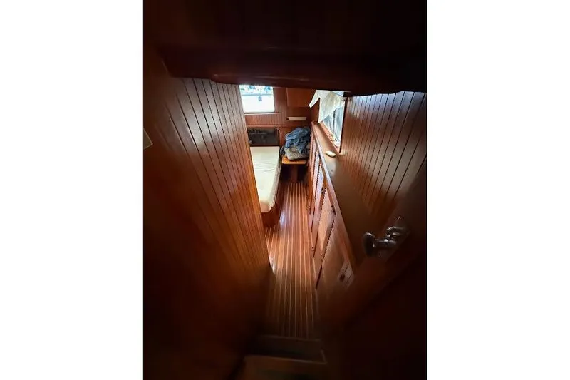 Slide: The Image of Interior view of 1987 Monk 36 Trawler, featuring wooden paneling and cozy cabin space. - 20