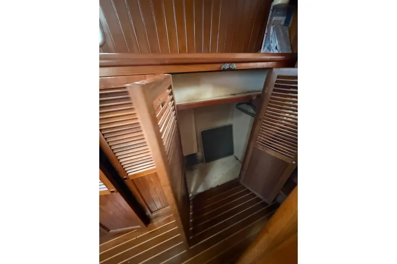 Slide: The Image of 1987 Monk 36 Trawler interior wooden closet with open louvered doors. - 24