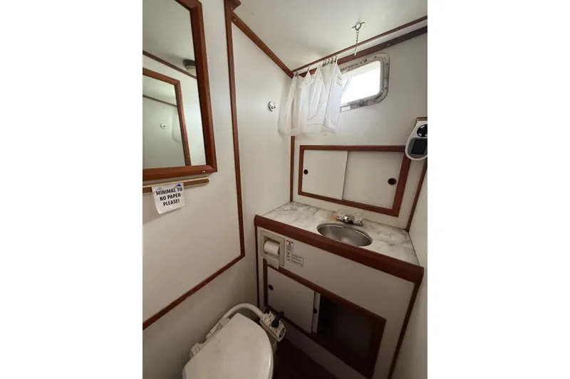 Slide: The Image of Bathroom interior of 1987 Monk 36 Trawler with sink, mirror, and toilet. - 25