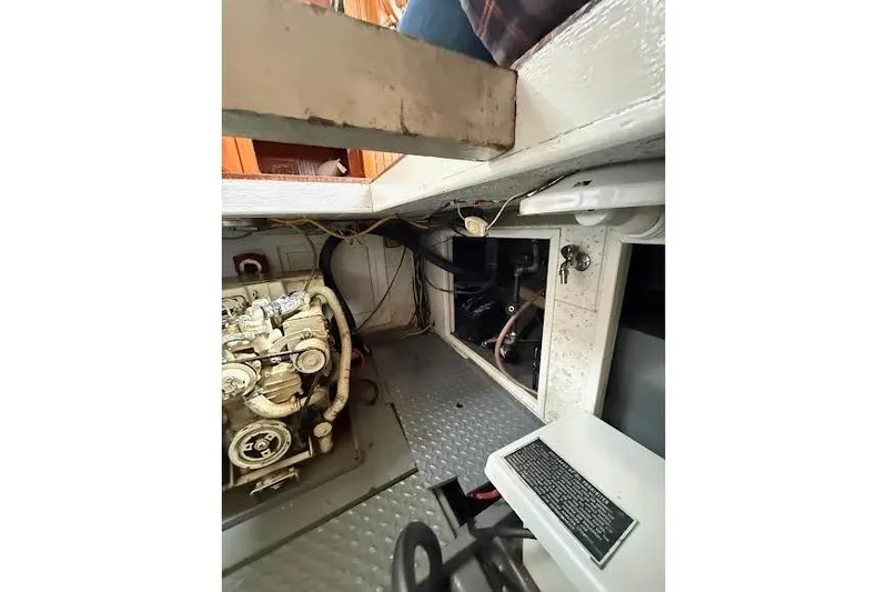 Slide: The Image of Engine room of a 1987 Monk 36 Trawler, showcasing mechanical components and wiring. - 29
