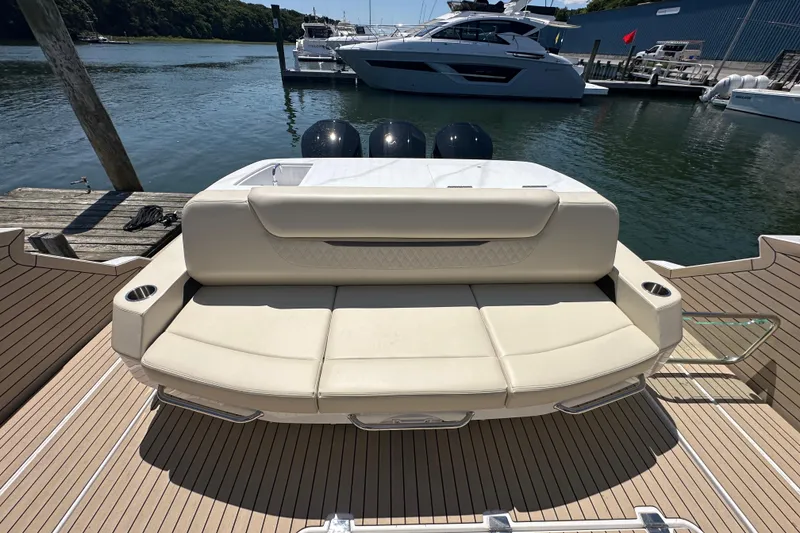 Slide: The Image of 2024 Cruisers Yachts 50 GLS luxury boat with spacious rear seating at a marina. - 26