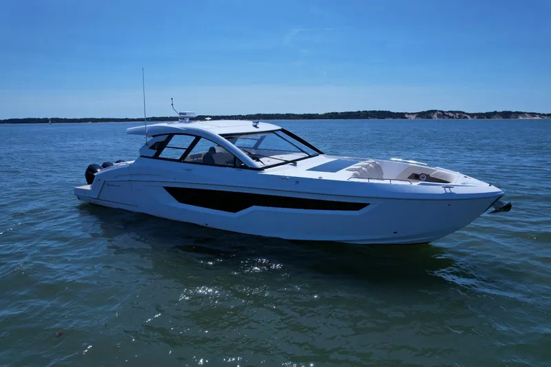 Slide: The Image of 2024 Cruisers Yachts 50 GLS luxury boat on calm water under clear blue sky. - 5