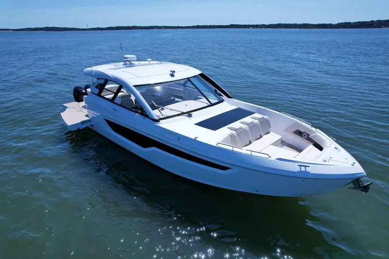 Slide: The Image of 2024 Cruisers Yachts 50 GLS luxury boat on calm blue water. - 4