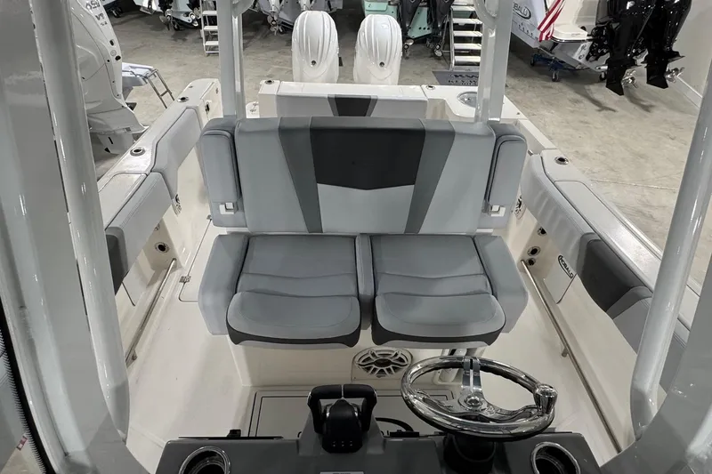 Slide: The Image of 2026 Robalo R270 Center Console boat interior with dual seats and steering wheel. - 11