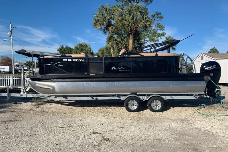 Slide: The Image of 2025 Barletta Cabrio 22QC pontoon boat on trailer, parked outdoors under clear sky. - 22