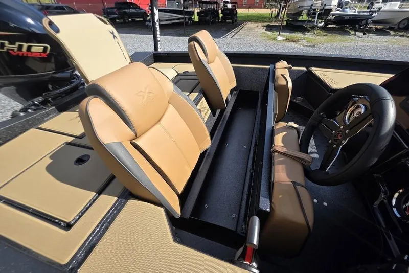 Slide: The Image of 2026 Xpress H17C Crappie boat interior with tan seats and steering wheel. - 16