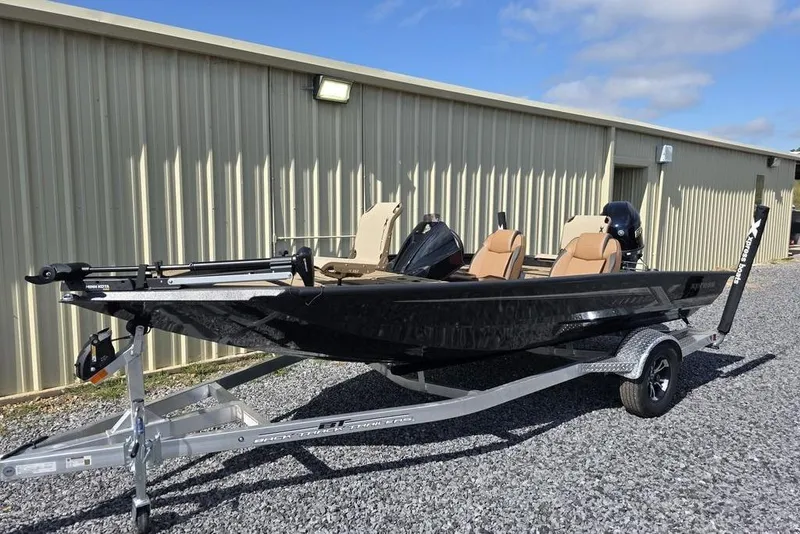 Slide: The Image of 2026 Xpress H17C Crappie boat on trailer, parked outside a metal building. - 3