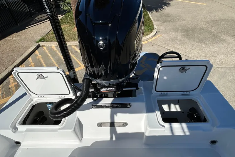 Slide: The Image of 2026 Shallow Sport 22 Sport boat with open storage compartments and powerful outboard motor. - 11
