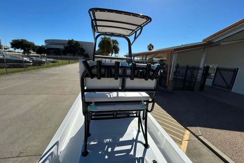 Slide: The Image of 2026 Shallow Sport 22 Sport boat with seating and canopy, parked outdoors. - 13