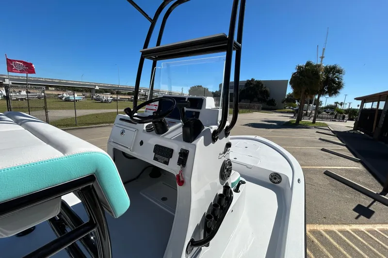 Slide: The Image of 2026 Shallow Sport 22 Sport boat interior with steering console and seating, parked outdoors. - 15