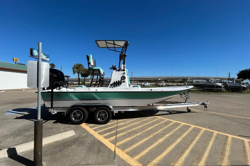 Slide: The Image of 2026 Shallow Sport 22 Sport boat on trailer in parking lot under clear blue sky. - 5