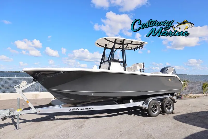 The Image of 2026 Sea Hunt Ultra 229 boat on trailer by waterfront, Castaway Marine logo visible. - 0