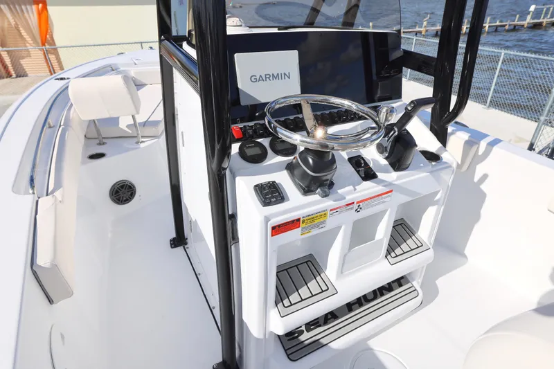 Slide: The Image of 2026 Sea Hunt Ultra 229 boat console with Garmin navigation system, docked by the water. - 20