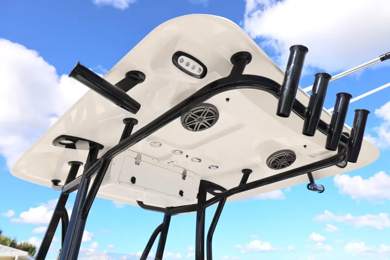 Slide: The Image of 2026 Sea Hunt Ultra 229 T-top with rod holders and speakers against blue sky. - 5