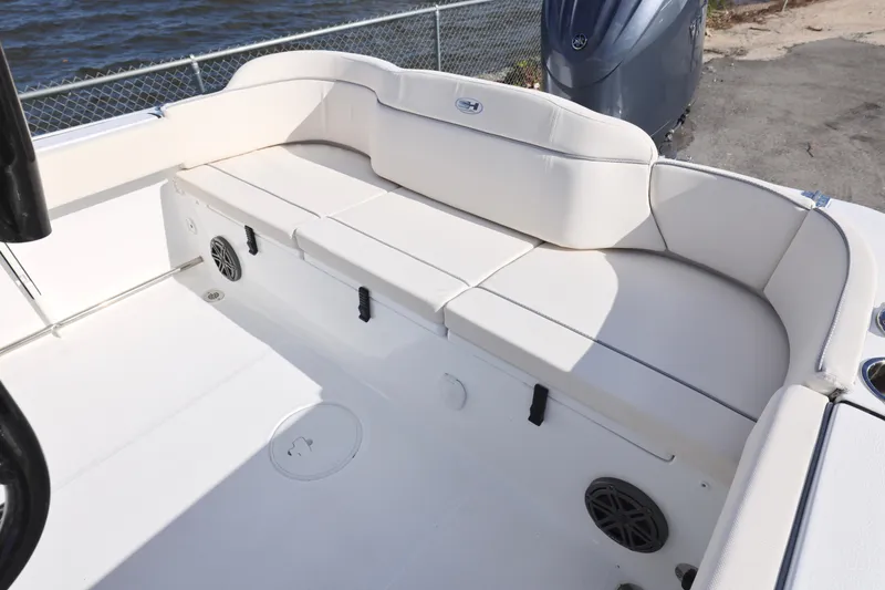 Slide: The Image of 2026 Sea Hunt Ultra 229 boat interior with white cushioned seating and speaker system. - 6