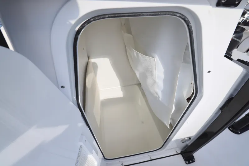 Slide: The Image of 2026 Sea Hunt Ultra 229 boat storage compartment, open hatch, white interior. - 9
